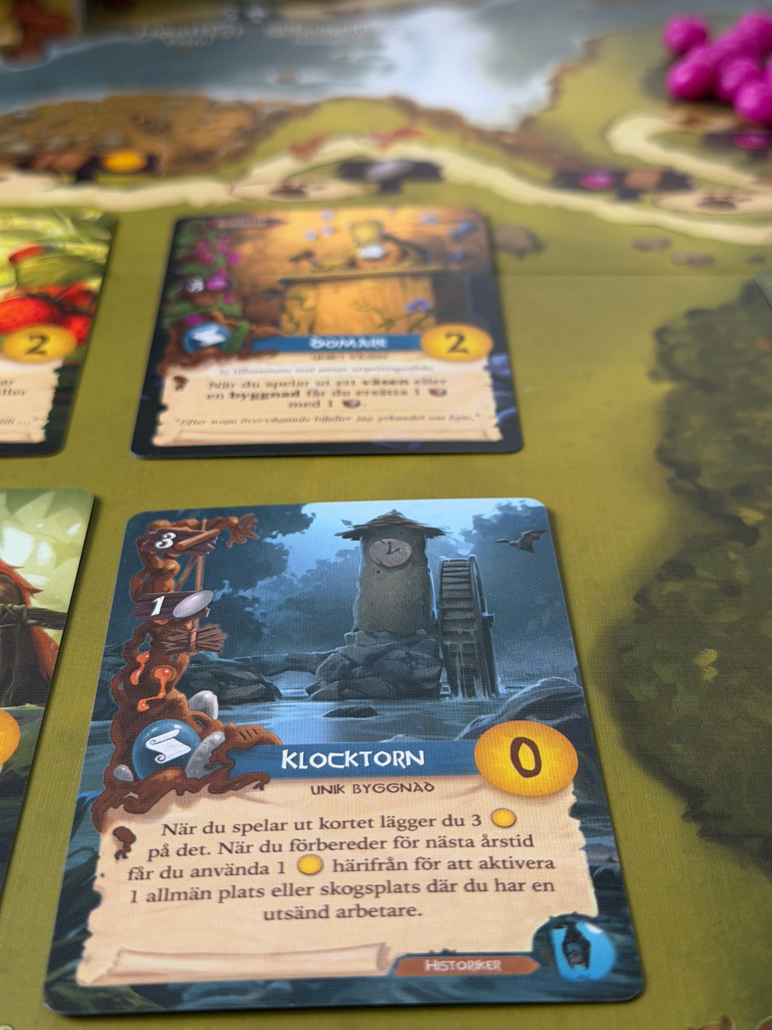 Kortet Klocktorn i skärpa på Everdells spelplan, med resten av bordet i oskärpa bakom.