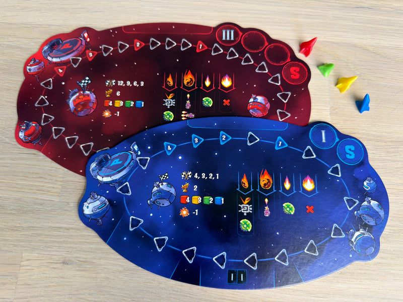 Galaxy Truckers två flygbrädor, den röda för tredje rundan och den blå för första, med fyra raketer i spelarfärgerna.