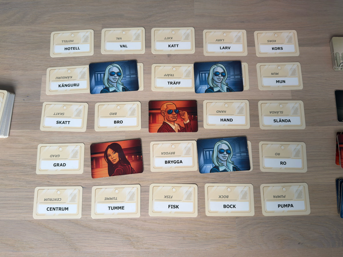 Codenames rutnät av svenska ordkort med agentkort utlagda över några av dem.